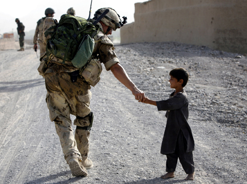 Afghan kid greeting a Canadian soldier